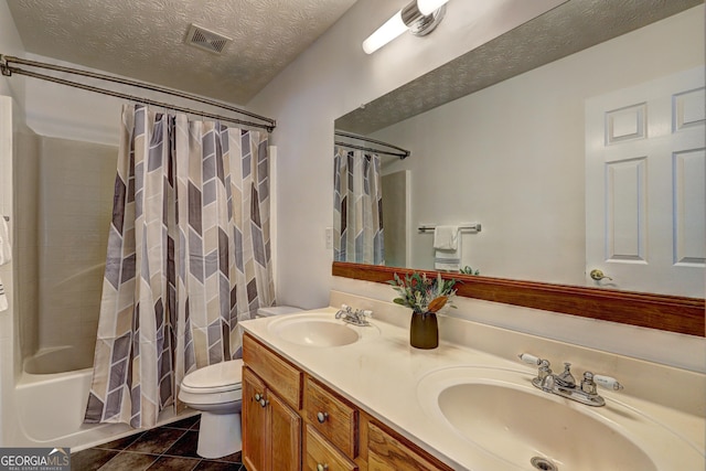 full bathroom featuring shower / bath combo, vanity, tile patterned flooring, toilet, and a textured ceiling