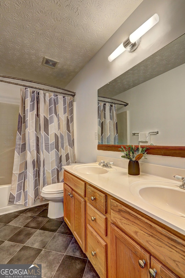 full bathroom featuring shower / bath combo, vanity, tile patterned flooring, toilet, and a textured ceiling