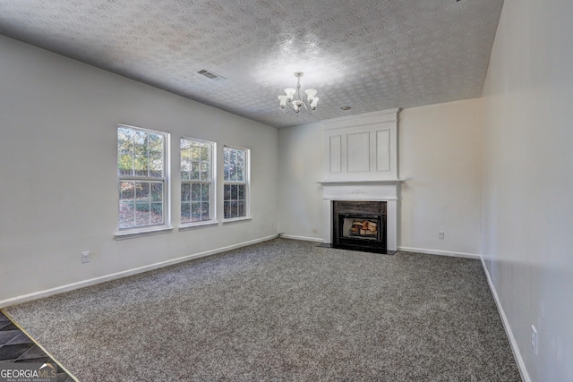 unfurnished living room featuring a chandelier, a textured ceiling, and carpet floors