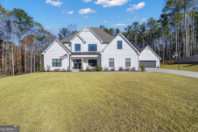 modern farmhouse style home with a front yard and a garage