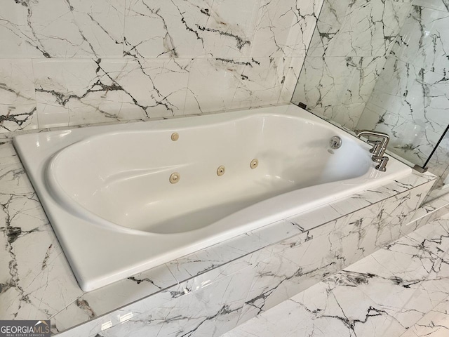 bathroom featuring tiled tub and tile walls