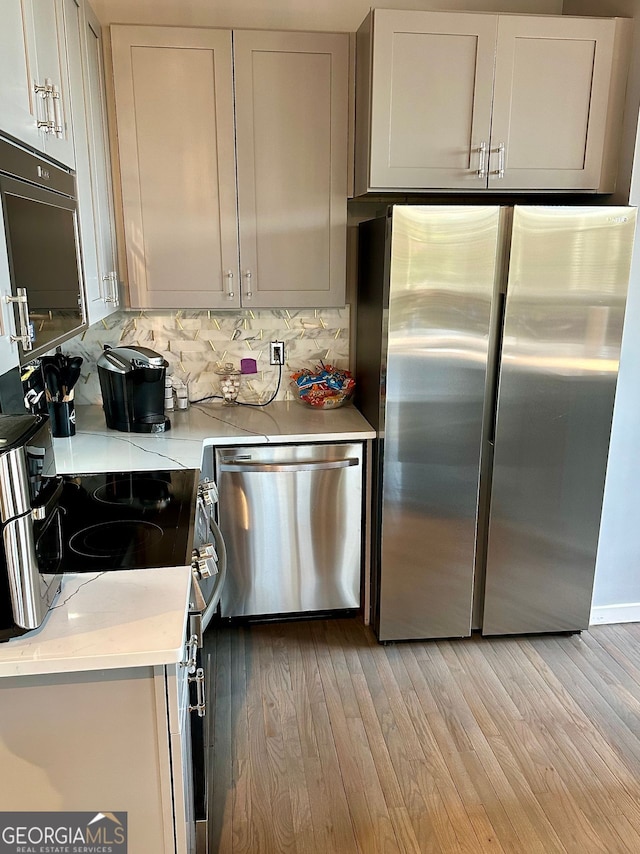 kitchen featuring tasteful backsplash, stainless steel appliances, and light hardwood / wood-style flooring