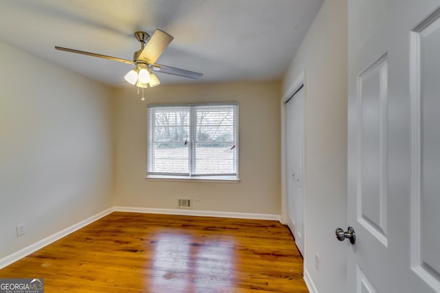 spare room with hardwood / wood-style floors and ceiling fan