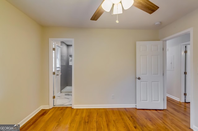 unfurnished bedroom featuring ceiling fan, ensuite bathroom, and light hardwood / wood-style flooring