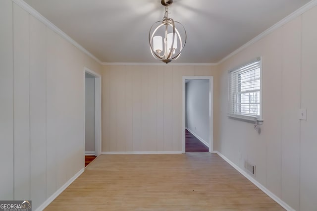 unfurnished dining area with ornamental molding, a notable chandelier, and light hardwood / wood-style flooring