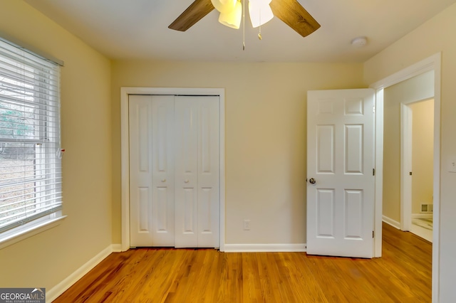 unfurnished bedroom featuring light hardwood / wood-style flooring, ceiling fan, and a closet