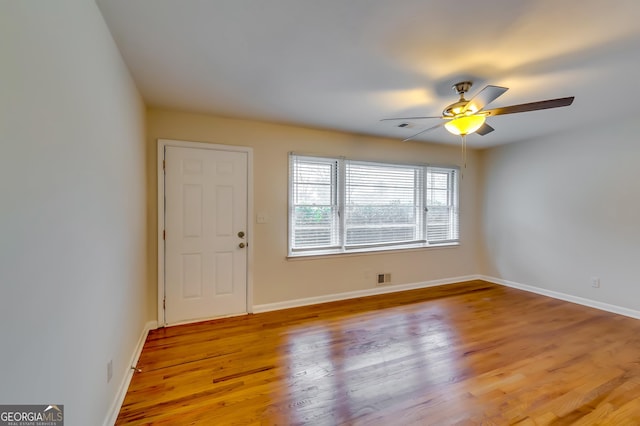 spare room with ceiling fan and light wood-type flooring