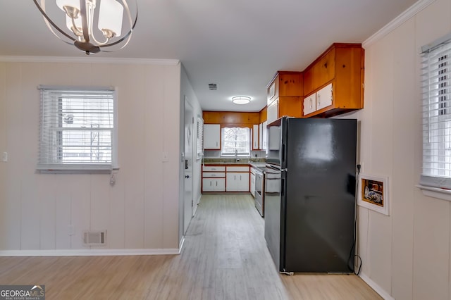 kitchen with black refrigerator, a wealth of natural light, ornamental molding, and electric stove