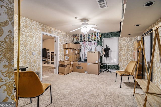 living area featuring light carpet and ceiling fan