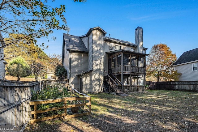 back of house with a lawn and a sunroom