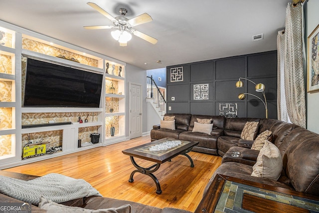 living room with ceiling fan, built in features, and hardwood / wood-style flooring