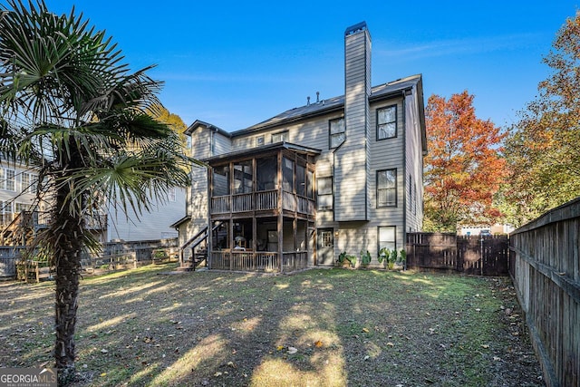 rear view of property with a sunroom and a yard