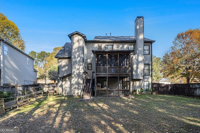 rear view of property featuring a sunroom and a yard