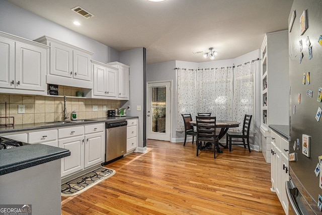 kitchen with light wood-type flooring, white cabinetry, sink, and appliances with stainless steel finishes