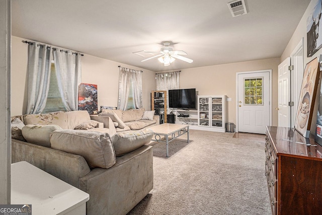 carpeted living room with ceiling fan