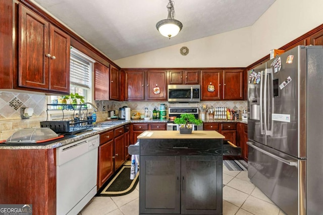 kitchen featuring sink, stainless steel appliances, a kitchen island, lofted ceiling, and light tile patterned floors