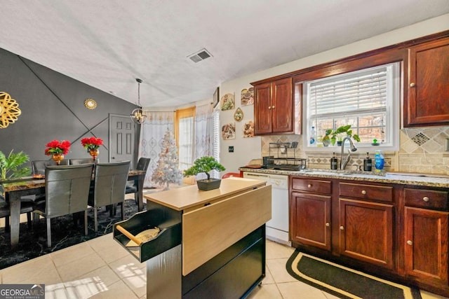 kitchen featuring dishwasher, sink, backsplash, lofted ceiling, and decorative light fixtures