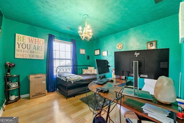 bedroom featuring a notable chandelier and light wood-type flooring