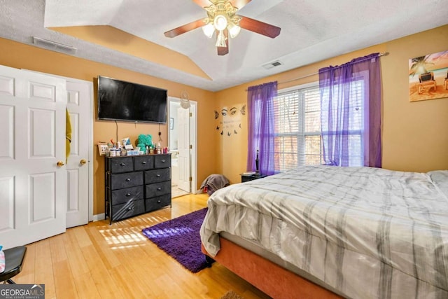 bedroom featuring wood-type flooring, a textured ceiling, vaulted ceiling, and ceiling fan