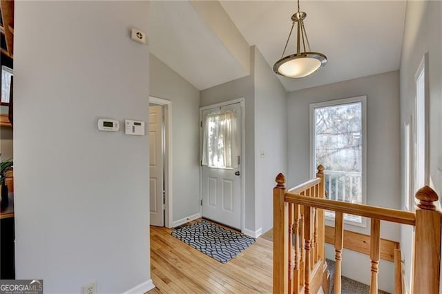 entrance foyer featuring vaulted ceiling and light hardwood / wood-style flooring