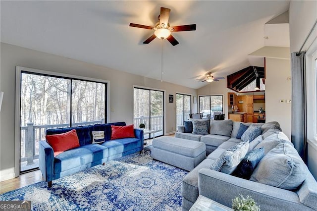 living room featuring hardwood / wood-style flooring, ceiling fan, and vaulted ceiling