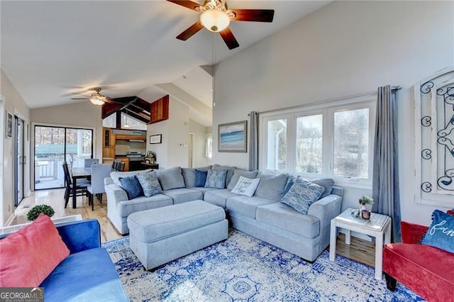 living room featuring ceiling fan, light wood-type flooring, and vaulted ceiling