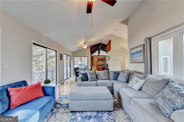 living room featuring ceiling fan, lofted ceiling, and light wood-type flooring