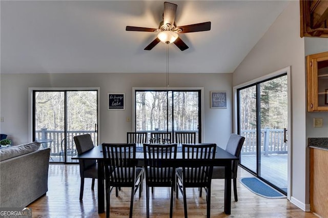 dining space featuring plenty of natural light, light hardwood / wood-style floors, and vaulted ceiling