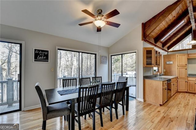 dining area with beamed ceiling, ceiling fan, a healthy amount of sunlight, and light hardwood / wood-style floors