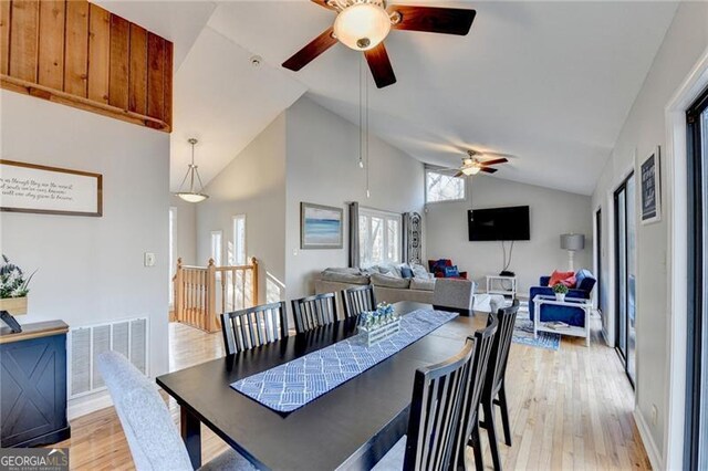 dining space with high vaulted ceiling, light hardwood / wood-style flooring, and ceiling fan