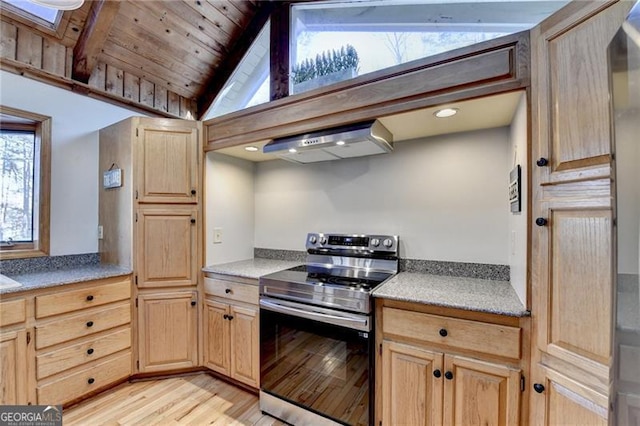 kitchen with vaulted ceiling with skylight, plenty of natural light, stainless steel range with electric stovetop, and exhaust hood