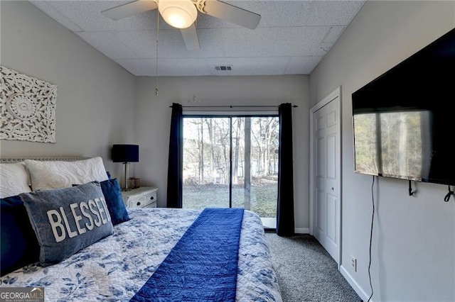 bedroom featuring carpet flooring, access to exterior, a drop ceiling, and ceiling fan