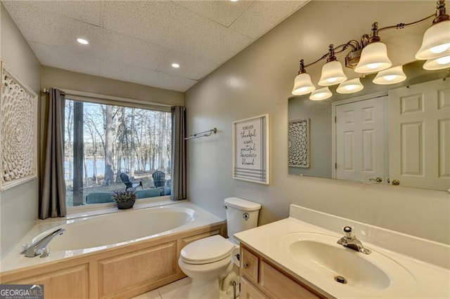 bathroom featuring tile patterned floors, a bathtub, vanity, and toilet