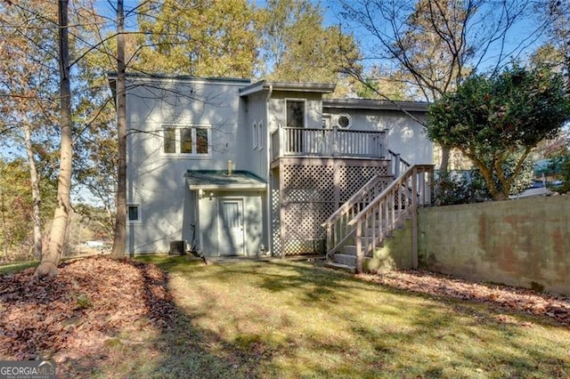 rear view of property featuring a lawn and a wooden deck