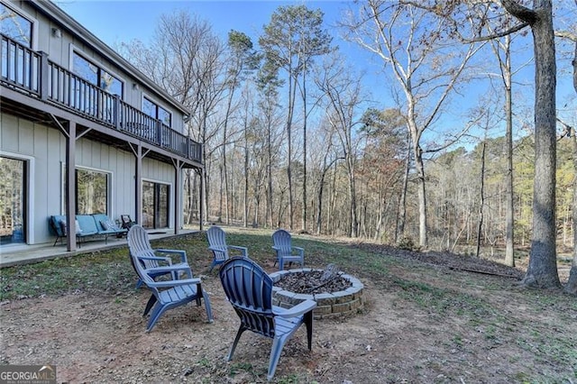 view of yard with a balcony, a patio, and a fire pit