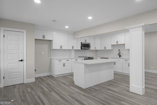 kitchen with white cabinets, a center island, sink, and stainless steel appliances