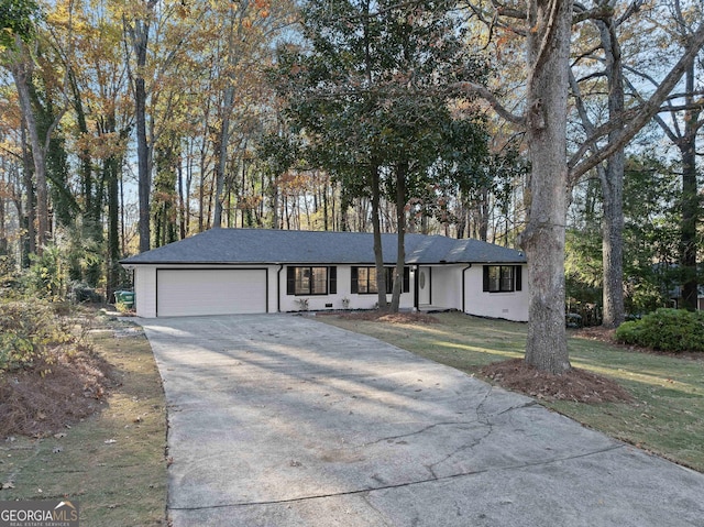 ranch-style house featuring a garage and a front lawn