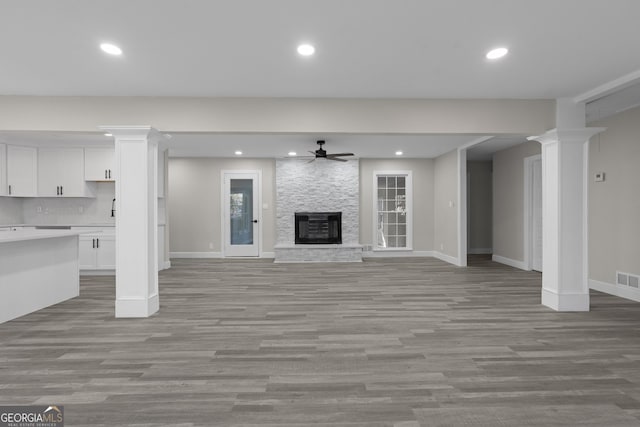 unfurnished living room with a fireplace, light hardwood / wood-style flooring, and ceiling fan