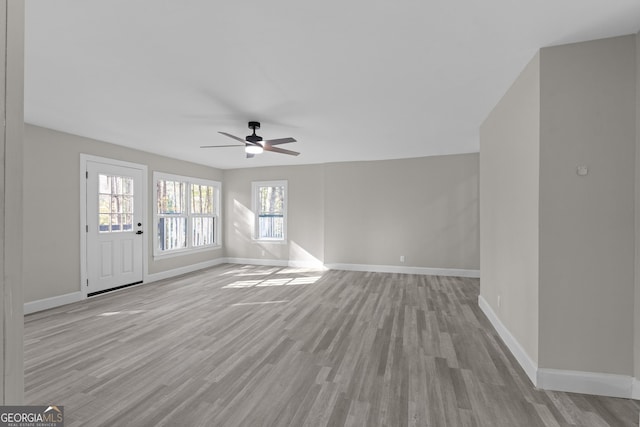 unfurnished living room featuring ceiling fan and light wood-type flooring