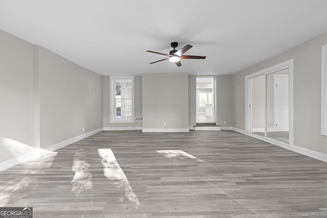 unfurnished room with ceiling fan and light wood-type flooring