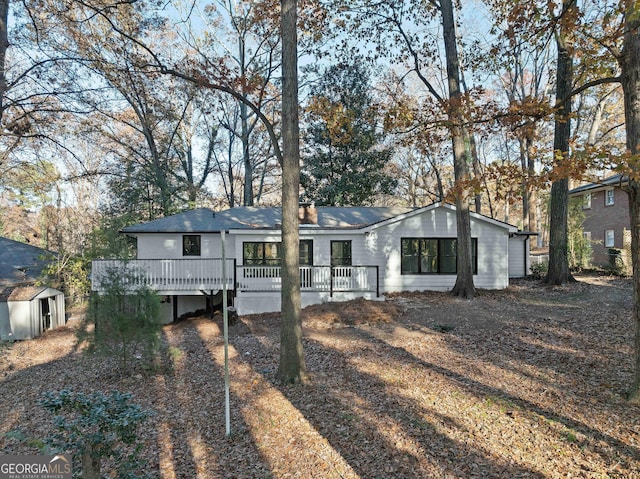 view of front of property featuring a deck and a storage unit