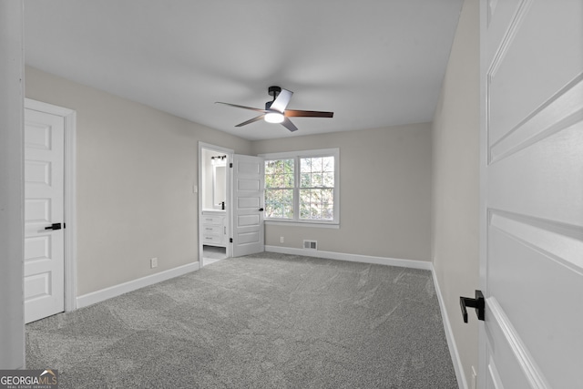 unfurnished bedroom featuring ensuite bath, ceiling fan, and carpet