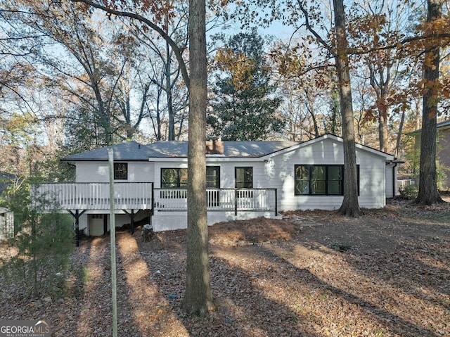 rear view of house featuring a wooden deck