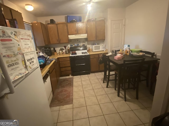 kitchen with light tile patterned flooring and white appliances