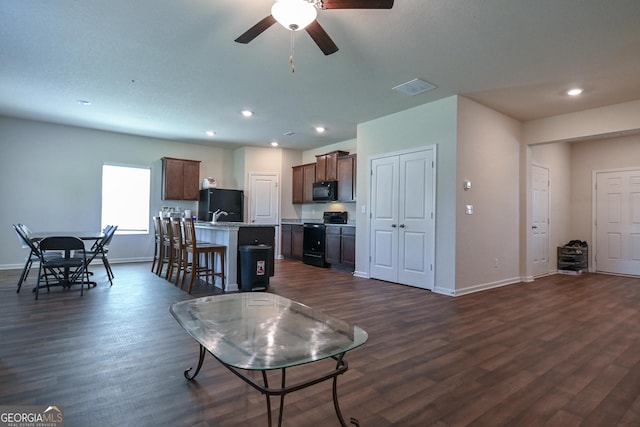 living room featuring ceiling fan and dark wood-type flooring