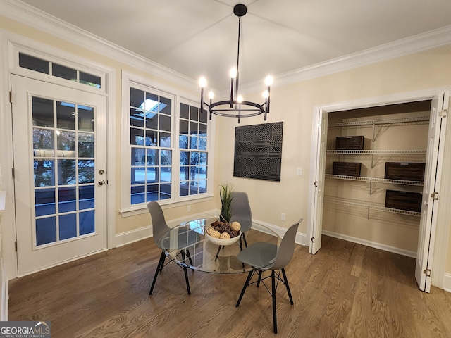 dining room with a chandelier, wood-type flooring, and crown molding