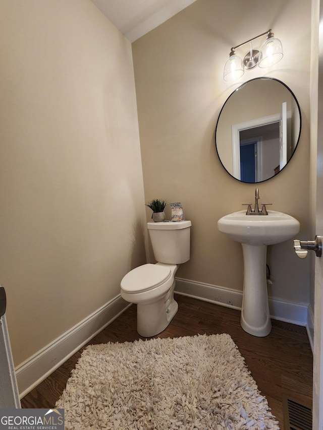 bathroom with toilet, vaulted ceiling, and hardwood / wood-style flooring