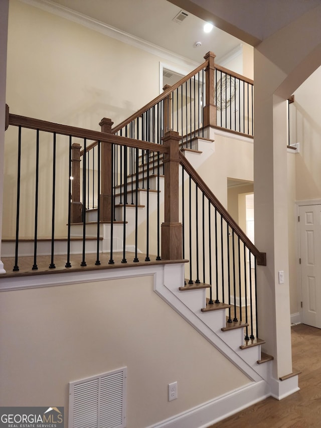 staircase featuring a high ceiling and hardwood / wood-style flooring