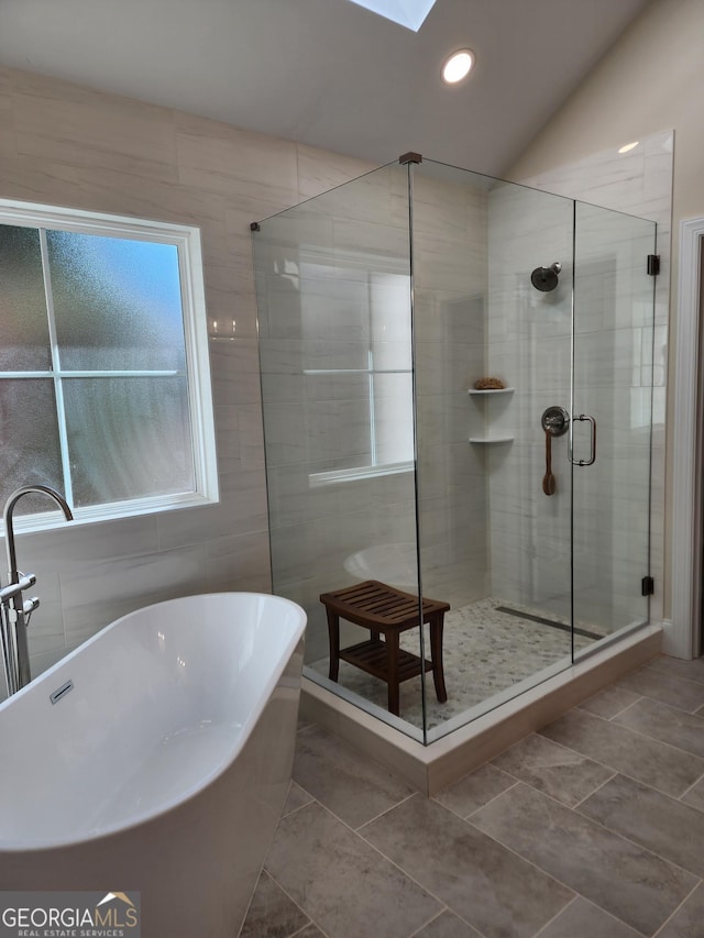 bathroom featuring tile patterned flooring, shower with separate bathtub, and lofted ceiling