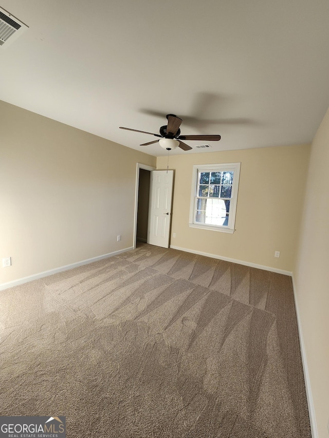 carpeted spare room with ceiling fan